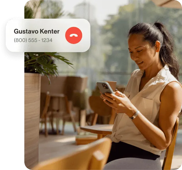 A lady sitting on a wood chair receives a call from Gustavo Kenter