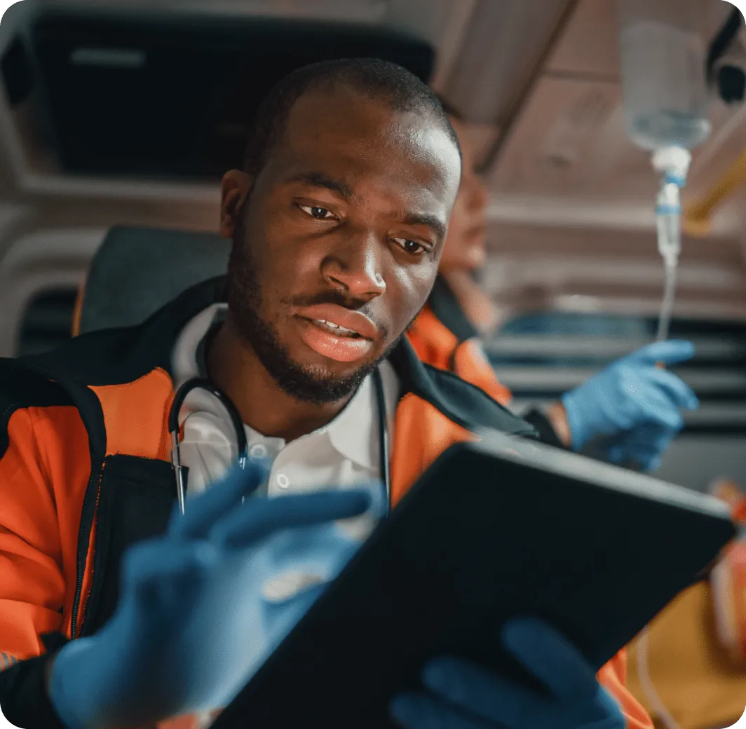  A male first responder holding a tablet inside an emergency van