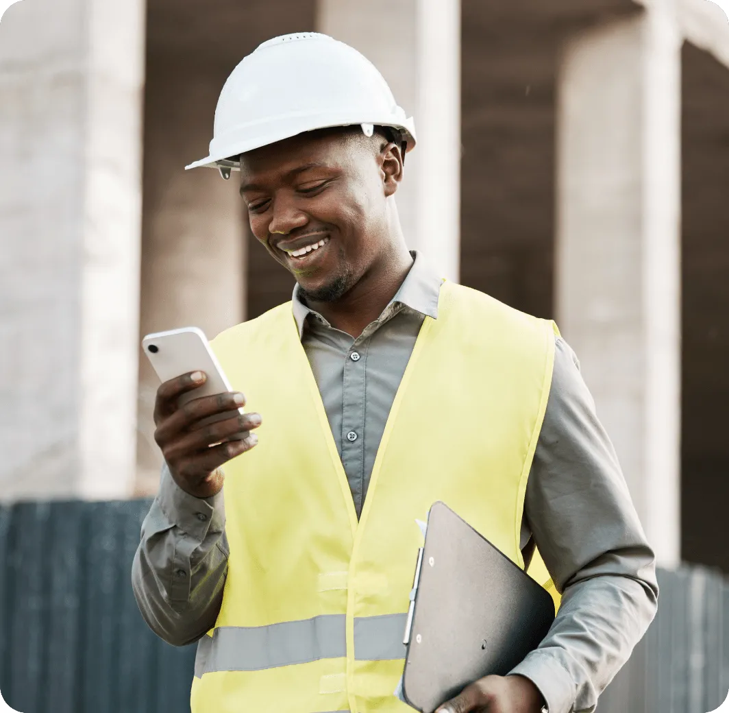 A male engineer looking at his phone in a construction site