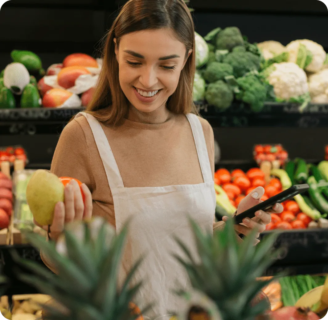 A woman holding a mobile phone in a grocery