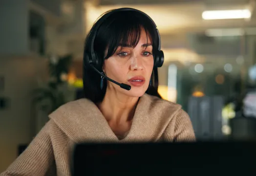 A woman wearing a headset takes a call